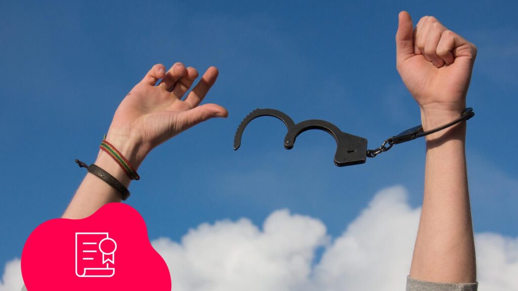 Hände in der Luft, die sich von Handschellen befreit haben