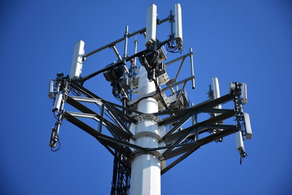 Nahaufnahme einer Mobilfunkantenne mit blauem Himmel im Hintergrund.
